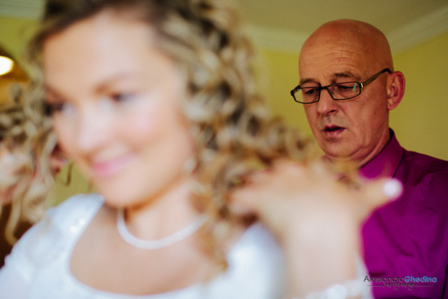 groom helps bride to get ready