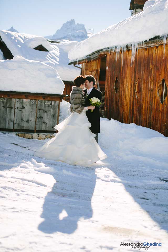 coppia di sposi si abbraccia nella neve