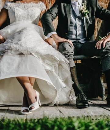 gli sposi a cortina d'ampezzo fanno vedere i calzini per una divertene fotografia di matrimonio