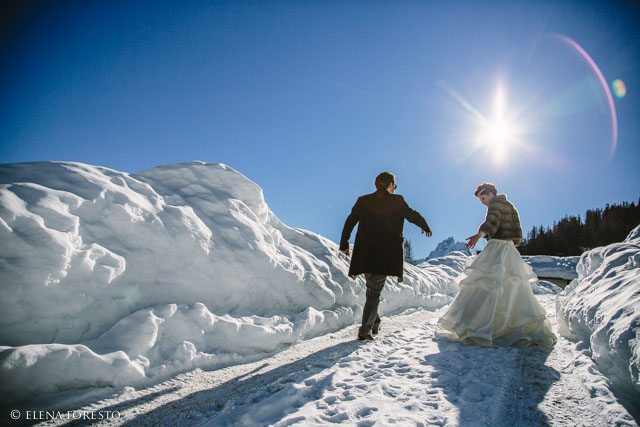 bride and groom walking together in the snow